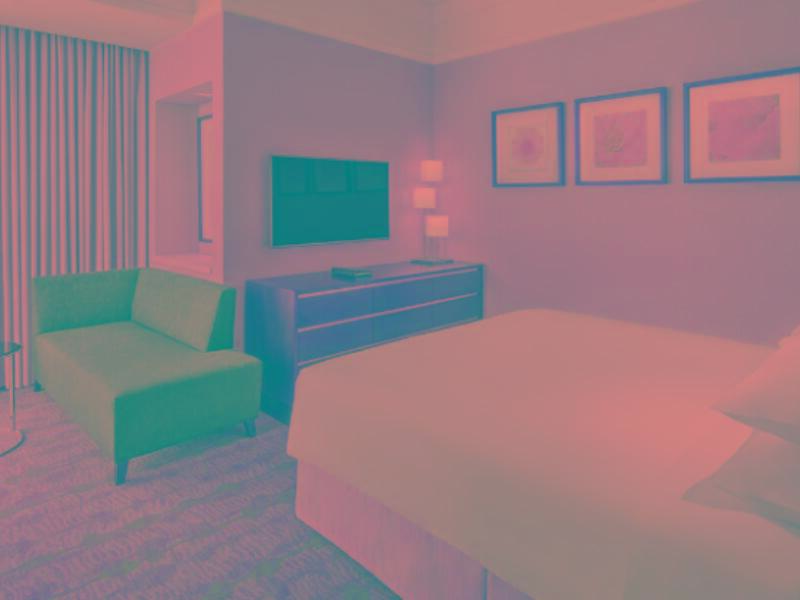 ホテル ジャバール オマール ハイアット リージェンシー マカー メッカ エクステリア 写真 The photo shows a hotel room featuring a comfortable setting. There is a large bed with white linens, positioned next to a stylish dresser. A flat-screen television is mounted on the wall opposite the bed. To one side, there is a small green sofa and