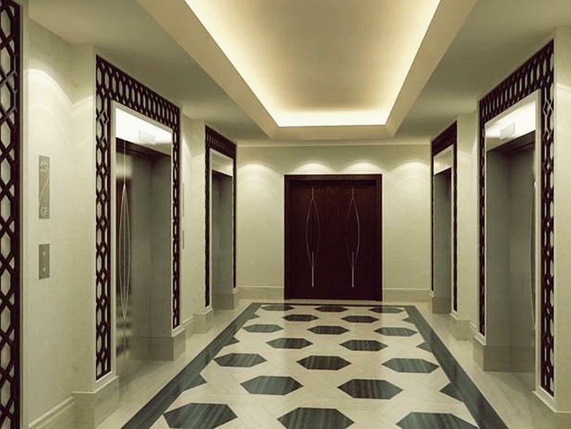 ホテル ジャバール オマール ハイアット リージェンシー マカー メッカ エクステリア 写真 The photo shows a modern, elegantly designed hotel hallway. It features a symmetrical layout with two sets of elevators on either side. The walls are a soft cream color, which enhances the overall brightness of the space. A sophisticated pattern can 